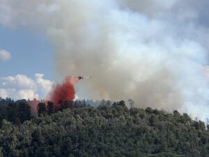 Photo of fire smoke and airplane dropping retardant on Thunder Fire