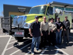 Five men standing in front of wildland engine donated to Montrose County